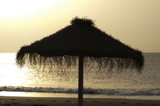 Straw umbrella on sunrize.