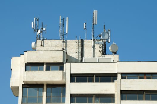 GSM transmitters on a roof of white administrative building