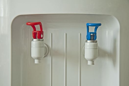 Hot and cold water machine with red and blue spouts