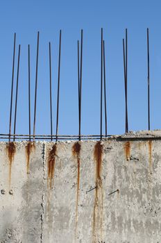 Old reinforcing steel protruding from the concrete. Blue sky background