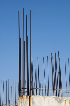 Old reinforcing steel protruding from the concrete. Blue sky background