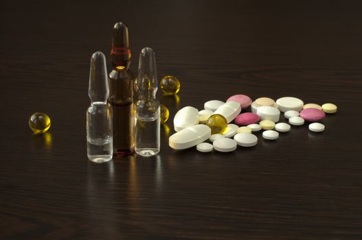 Pile drugs and ampoules on table