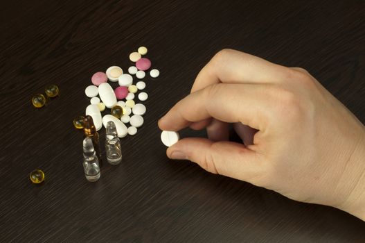 Drugs and Hand holding white pill