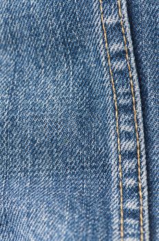 Orange stitch on the denim garment very close up.Jeans background