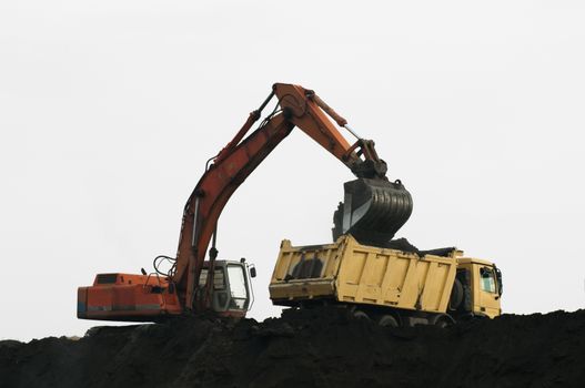 Excavator loading truck. White isolated