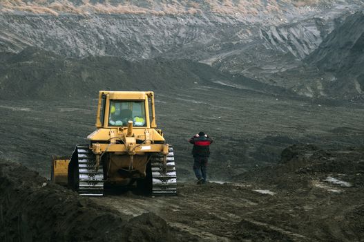 Excavator with tracks and worker