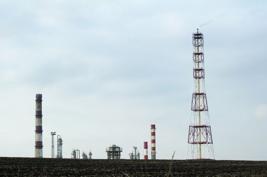 Oil and chemical refinery for production of petroleum products. Land on foreground. Flame