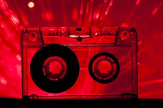 Transparent Cassette tape and red color disco lights background