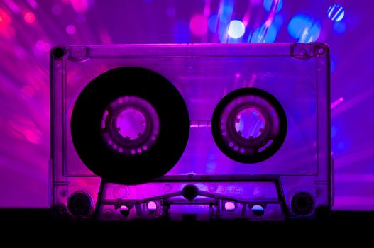 Transparent Cassette tape and blue pink color disco light background