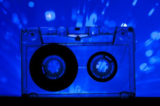 Transparent Cassette tape and blue color disco light background
