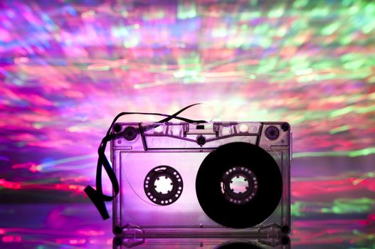 Cassette tape and multicolored pink blue lights on background