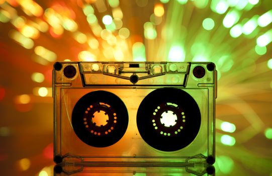 Cassette tape and multicolored yellow green lights on background