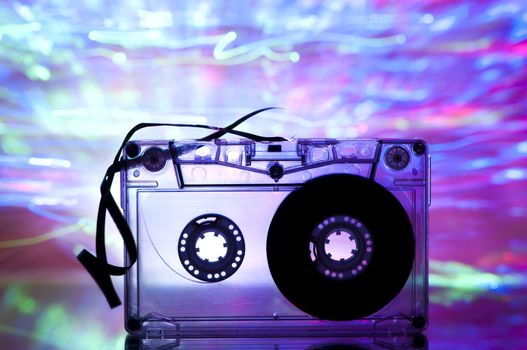 Cassette tape and multicolored pink blue lights on background