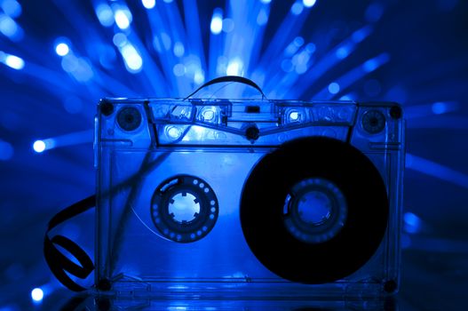 Cassette tape and multicolored blue lights on background