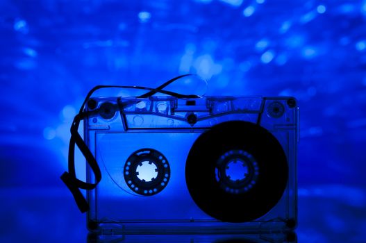 Cassette tape and multicolored blue lights on background