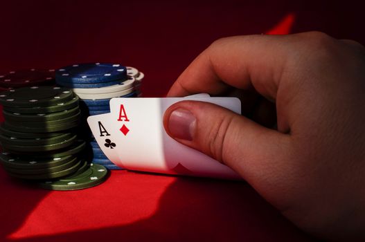 Two aces high on red table with chips on black background