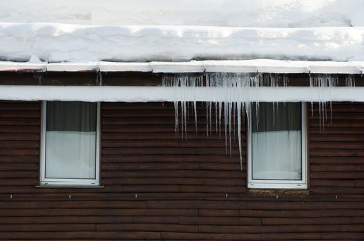 Icicles on window. Wooden house windows