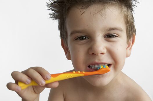 Boy washing teeth with toothbrush
