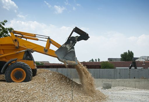 Yellow excavator unload gravel