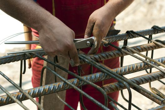 Construction worker ties reinforcing steel rebar. Close up 