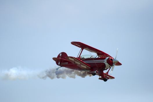 Red plane looping in a blue sky. Close up