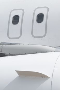 Windows of an airplane outside. White color plane. Vertical image