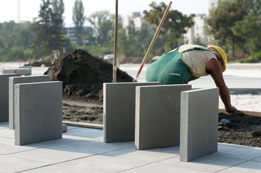 A worker puts exterior tiles 