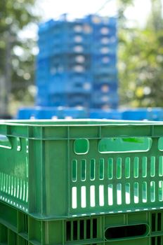 Green plastic crates. Blurred blue background