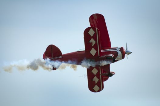 Red plane looping in a blue sky. Close up