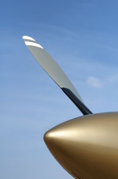 Beige and white plane propeller on blue sky background