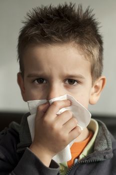 Child suffering from a cold. Cough with a tissue
