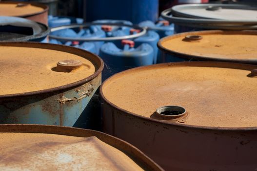 Old colored barrels for oil products. Empty rusted drums
