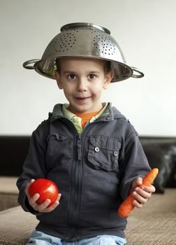 Boy with tomato and carrot in hand. Vertical image