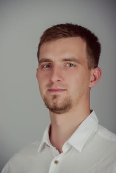 Portrait of a smiling young brunette man in studio