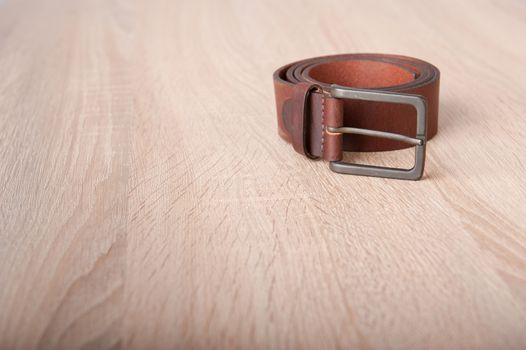 Leather belt on the wooden desk table