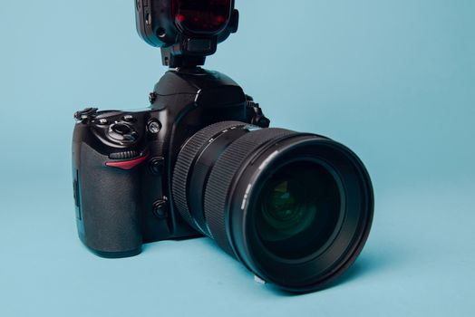Professional modern DSLR camera against blue background