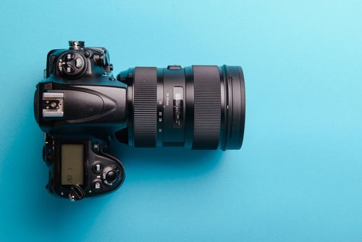Professional modern DSLR camera against blue background
