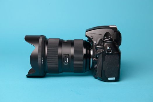 Professional modern DSLR camera against blue background