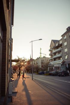 City street in early spring with pink cherry tree at dusk