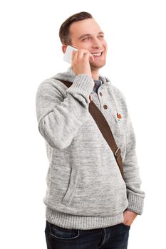 Portrait of a confident smiling man or student in casual clothes and a shoulder bag talking on mobile phone, isolated on a white background.