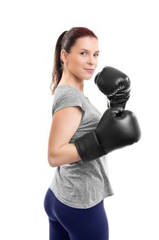 Portrait of a beautiful young woman with boxing gloves in a stance with raised arms, isolated on white background.