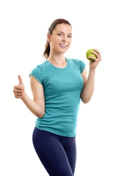 Healthy, lifestyle, diet, weight loss concept. Portrait of a confident, sporty, smiling beautiful young woman in sports clothes, holding a green apple and giving thumb up, isolated on white background.