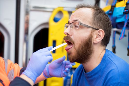 Emergency doctor in the ambulance examining a patient.