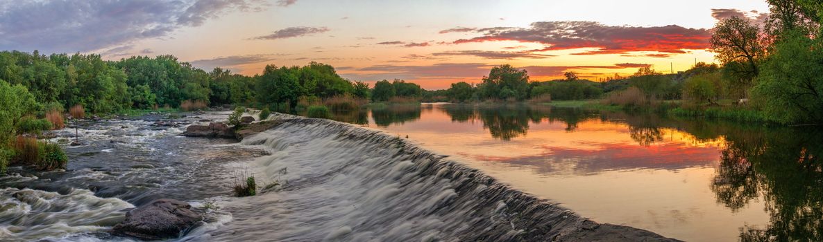 Beautiful view of the dam on the Southern Bug River at sunset. Village of Migiya, Ukraine, on a sunny summer evening