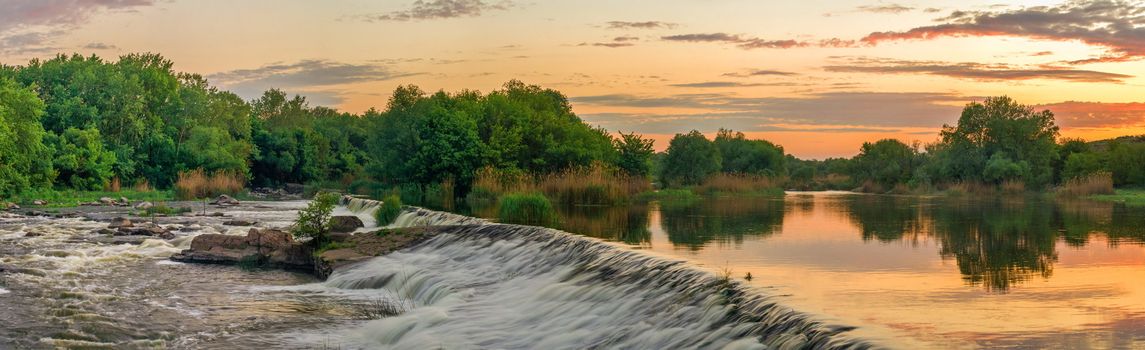 Beautiful view of the dam on the Southern Bug River at sunset. Village of Migiya, Ukraine, on a sunny summer evening