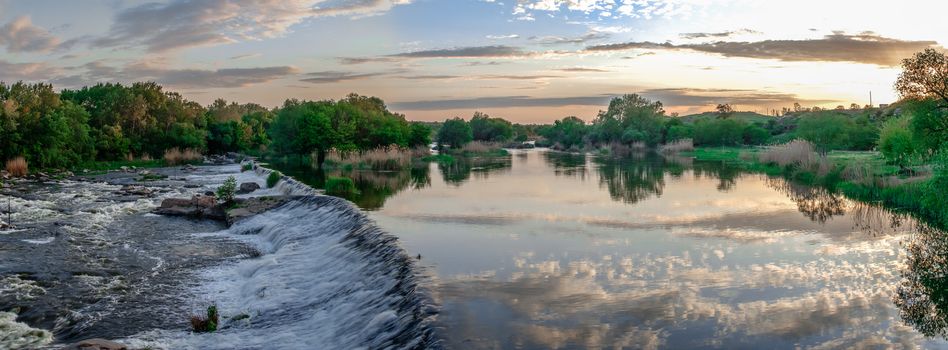 Beautiful view of the dam on the Southern Bug River at sunset. Village of Migiya, Ukraine, on a sunny summer evening