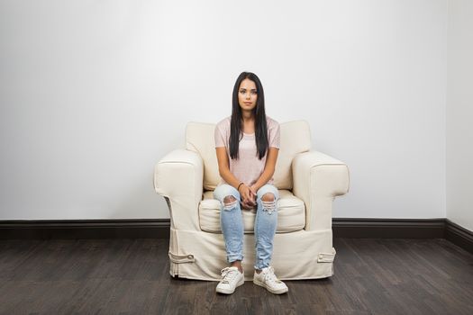 Young woman sitting on a white couch