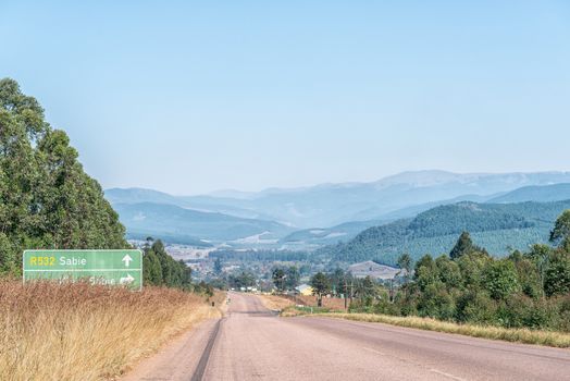 A view of the landscape on road R532 near Sabie. A directional sign is visible