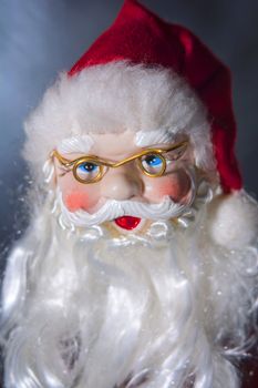 A photo of a Christmas tree ornament in the form of a Santa's head. Picture are modeled on a portrait photo style.