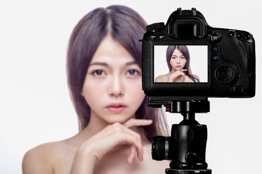 Asian American beauty vlogger creating content for social media vlog, behind camera shot